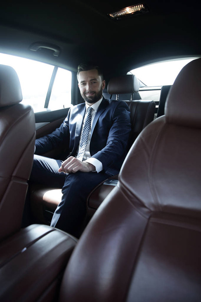 businessman sitting in the back seat of a car - 写真・画像