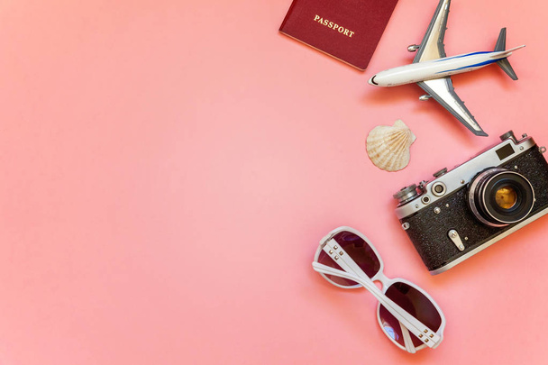 Flat Lay with plane, vintage camera, passport, sunglasses and shell on pink colourful pastel trendy modern fashion background. Vacation travel summer weekend sea adventure trip concept - Fotografie, Obrázek