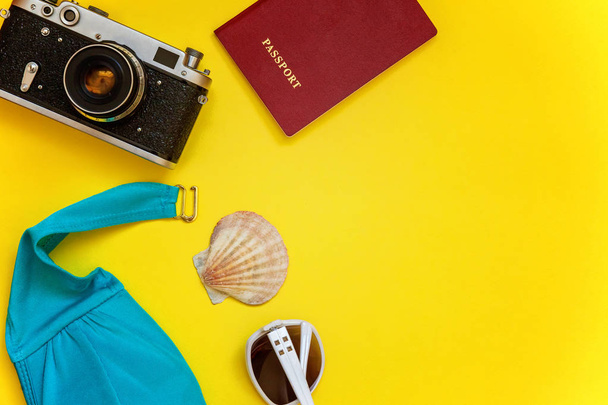 Düz Lay Bikini, çınar, bağbozumu kamera, pasaport, Güneş kremi, güneş gözlüğü ve kabuk üzerinde sarı renkli şık modern moda arka plan ile. Tatil seyahat yaz hafta sonu deniz macera seyahat kavramı - Fotoğraf, Görsel