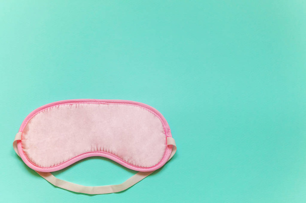 Sleeping eye mask, isolated on blue pastel colourful trendy background. Do not disturb me, let me sleep. Rest, good night, insomnia, relaxation, tired, travel concept - Photo, Image
