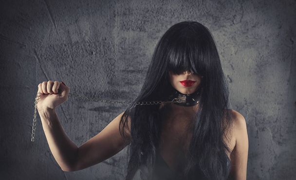 Sensual provocation of a sexy bdsm woman with chained neck - Photo, Image