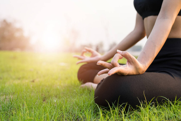Le donne si stanno esercitando con loto yoga pose su bella erba verde e luce del sole. Di sera. concetto sano
. - Foto, immagini