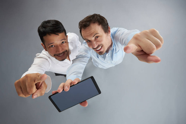 Two smiling mans holding smartphone - Foto, Imagem