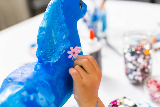 Malá holčička dekorační malované modrý papír hmota jednorožec. - Fotografie, Obrázek