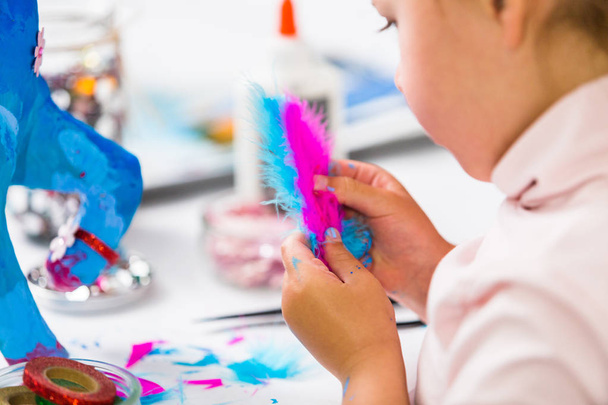 Malá holčička dekorační malované modrý papír hmota jednorožec. - Fotografie, Obrázek