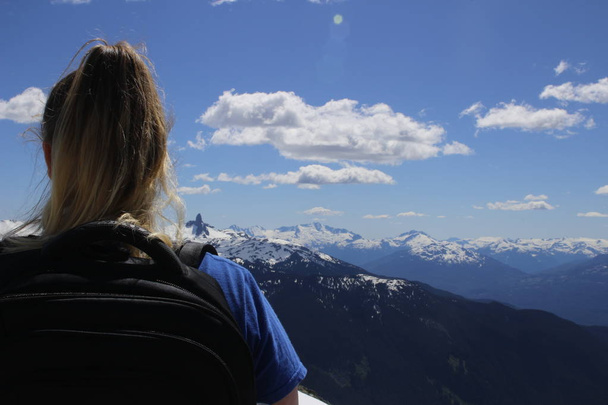 Travel Canada. Woman on mountain cliff against snow capped peak. Vancouver, Whistler. Stawamus Chief Park near Squamish. British Columbia. Canada. - Fotoğraf, Görsel