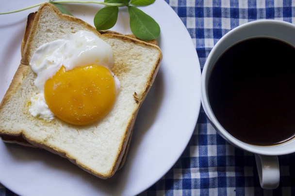 Huevo frito en tostadas y café negro en un vaso
. - Foto, Imagen
