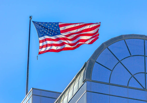 Bandeira americana soprando no vento na construção
 - Foto, Imagem