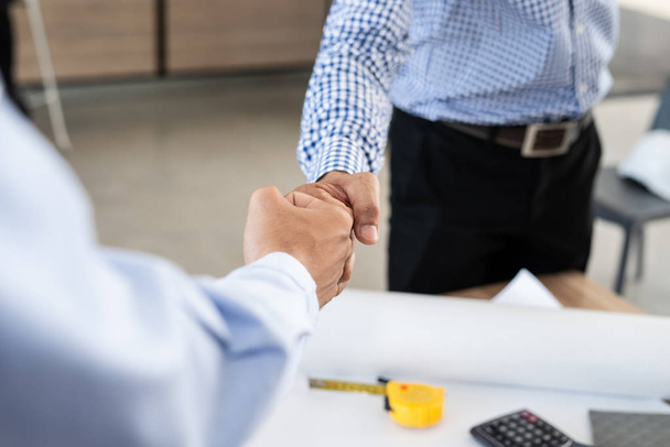 Az üzletember és a mérnök kéz a kézben püfölik egymást a sikeres csapatmunkáért. Partnerségi üzleti koncepció - Fotó, kép