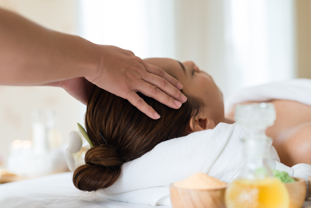 Bella ragazza asiatica rilassante ricevere massaggio facciale in un salone spa
 - Foto, immagini