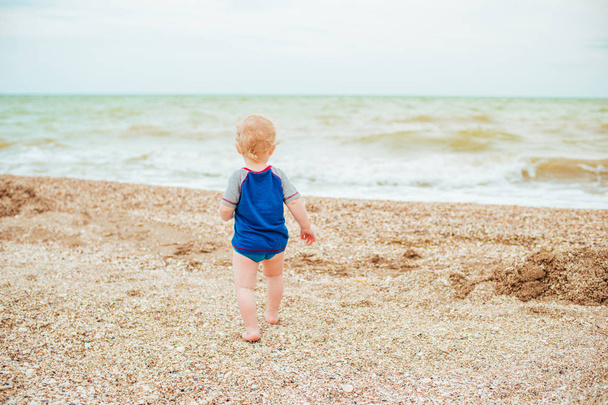 Baby boy playing at sea. Happy  boy enjoys life on summer beach - Foto, immagini