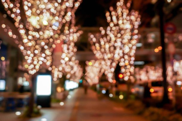 Nahaufnahme verschwommen und Bokeh der rosa LED-Reflexionsbeleuchtung schmücken Bäume am Valentinstag mit dem Nachtleben der Stadt in Osaka, Japan. - Foto, Bild