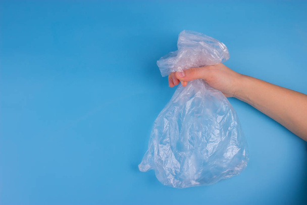 Plastic bag on blue background. pollution concept - Фото, изображение