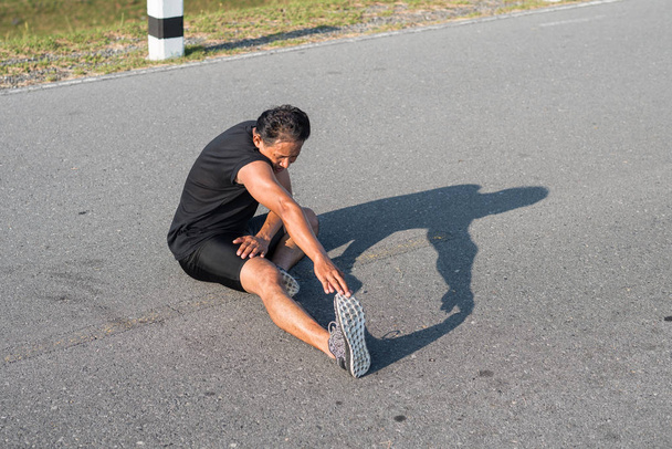 Мужчины-бегуны растягивают мышцы ног, чтобы подготовиться к утренней пробежке. Понятие здоровья и фитнеса
 - Фото, изображение