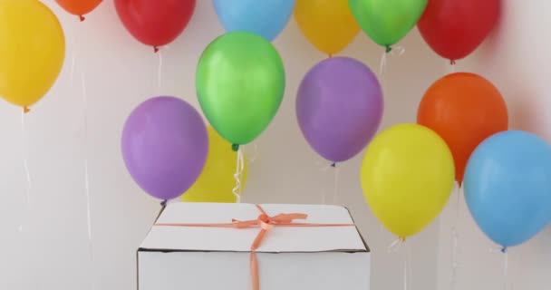 Kırmızı kurdele ve renkli balon beyaz hediye kutusu - Video, Çekim