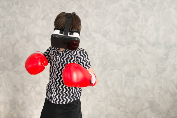 A boy is playing boxing game with 3D virtual reality headset. - Fotoğraf, Görsel