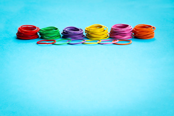 Έννοιας της ομαδικής εργασίας. ομάδα πολύχρωμα λαστιχένια ζώνη σε μπλε φόντο με αντίγραφο χώρου - Φωτογραφία, εικόνα