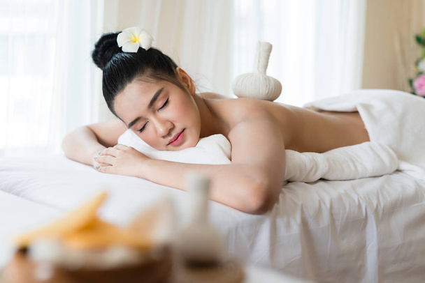 Comprimere posto sulla schiena di una ragazza asiatica in un massaggio spa in salone
 - Foto, immagini
