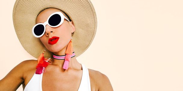 Model in stylish beach accessories. Sunglasses, earrings, hat. Beach fashion look - 写真・画像
