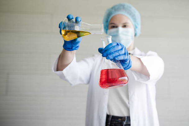 Ρωσική γυναίκα επιστήμονας στο εργαστήριο με γυάλινους σωλήνες. Δοκιμάστε ένα υγρό διάλυμα με φόρμουλα επιστήμης ή Χημείας - Φωτογραφία, εικόνα