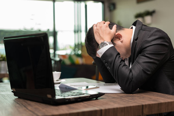 Frustrado estresado empresario asiático sentado en la cafetería con el ordenador portátil
 - Foto, Imagen