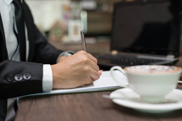 Close up Hand of businessman is signing a contract, business contract details at coffee shop - Foto, Bild