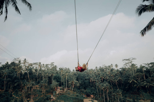 Femme s'amuser sur une balançoire dans la forêt asiatique
 - Photo, image
