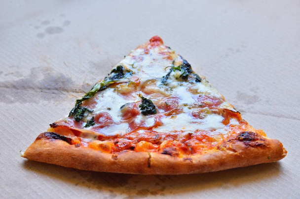 ausgezeichnete frische Pizza mit Käse, Speck und Spinat in einer Box. Lieferung von Lebensmitteln am Telefon ins Haus. - Foto, Bild