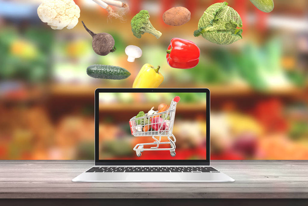 Koop verse biologische groenten met laptop computer concept. Groenten val die ik winkelwagen op beeldscherm. - Foto, afbeelding