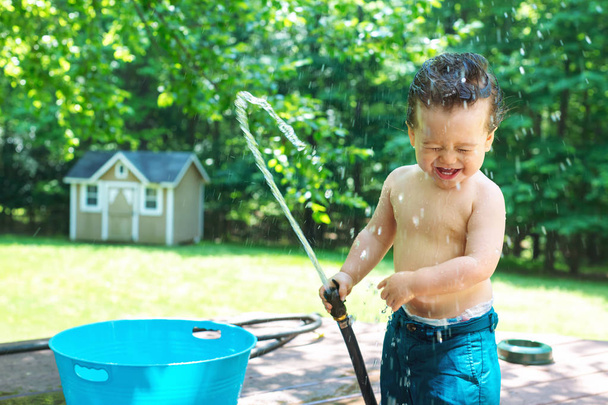 Giovane bambino ragazzo giocare con acqua
 - Foto, immagini