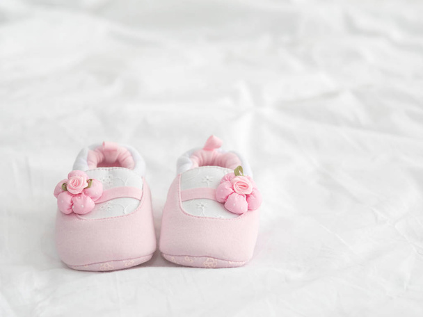 A pair of pink baby shoes on blanket with copy space. - Foto, Bild