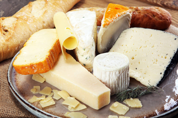 Bandeja de queso con diferentes quesos en plato rústico
. - Foto, Imagen