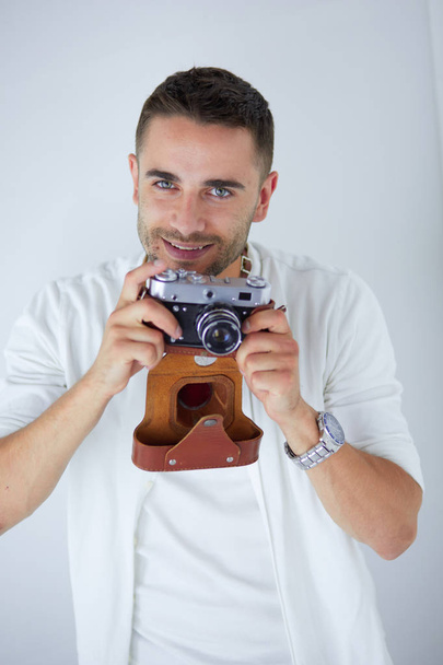 Young man with camera. Isolated over white background - Fotó, kép