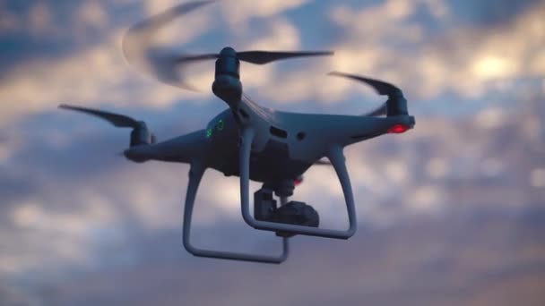 Drone UAV quadcopter z aparatu cyfrowego w zachód słońca niebo. Zbliżenie na zewnątrz drona. - Materiał filmowy, wideo