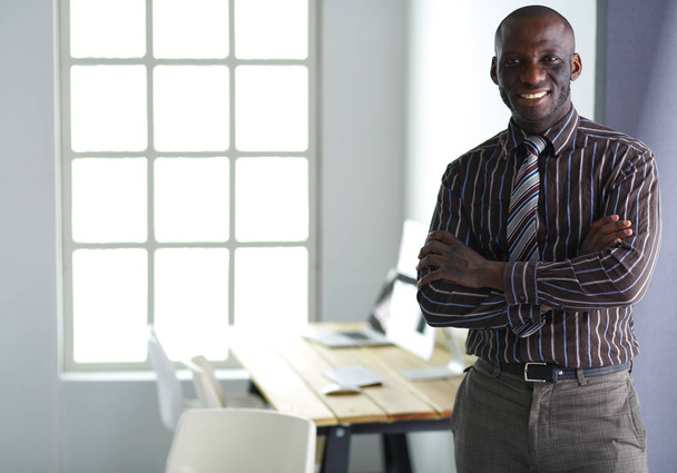 Portrait of an handsome black businessman standing in office - Photo, image