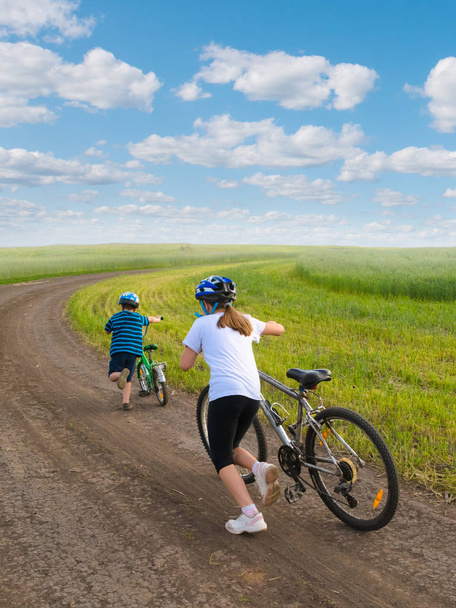 Спортивні діти ходять в гору з велосипедами
 - Фото, зображення
