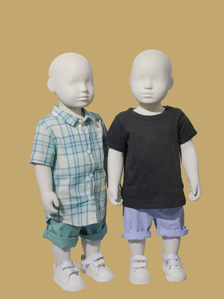 2 人の子供のマネキンは分離されたカジュアルな子供服に身を包んだ。ないブランド名や著作物. - 写真・画像