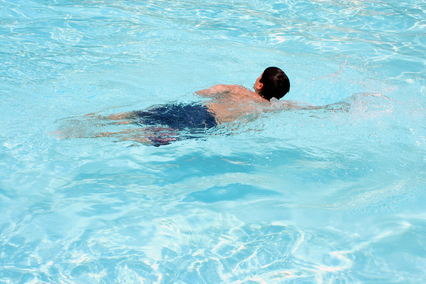 Teenage boy swimming in a pool - 写真・画像