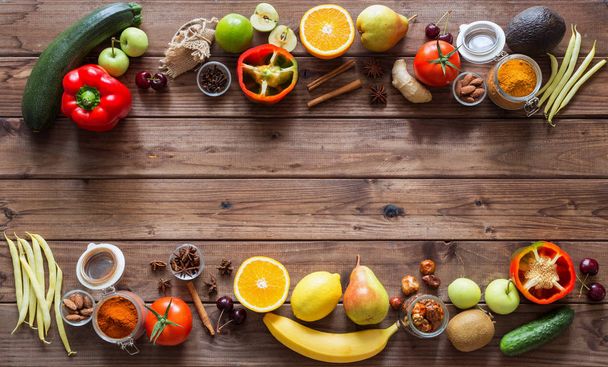 Comida saludable, selección de alimentos limpios: frutas, verduras, semillas, especias en tablas marrones con espacio libre en el medio
 - Foto, Imagen