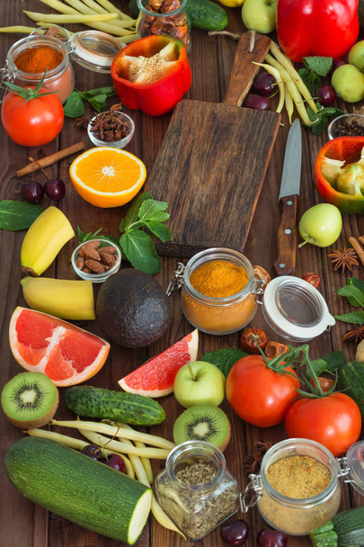 Terveellinen ruoka, puhdas ruokavalikoima: hedelmät, vihannekset, siemenet, mausteet puupohjalla
 - Valokuva, kuva