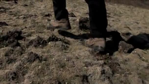 Pies de excursionista caminando al aire libre sobre terreno desigual áspero
 - Metraje, vídeo