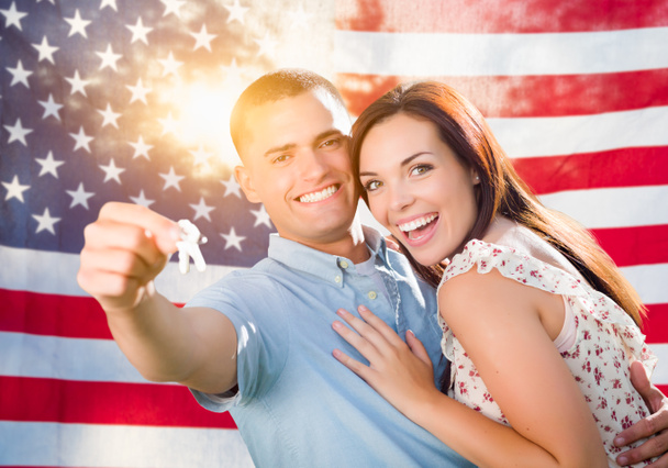 Militar pareja sosteniendo llaves de la casa en frente de la bandera americana
 - Foto, imagen