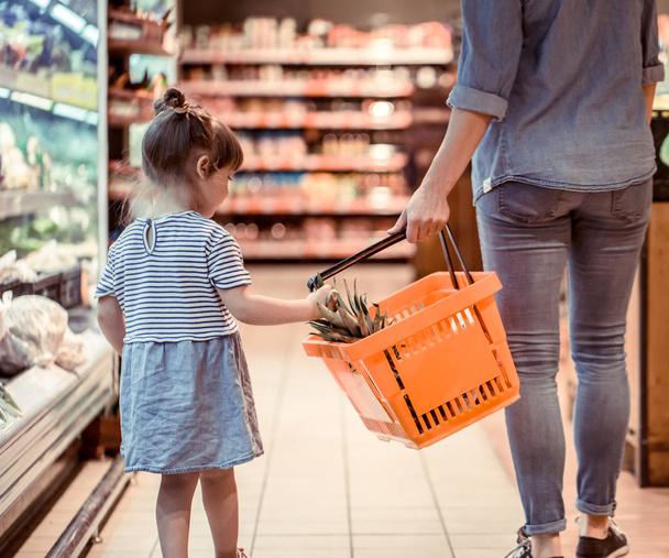 Moeder en dochter zijn winkelen bij de supermarkt, het concept van familierelaties en gezond eten - Foto, afbeelding