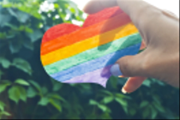 Concetto di giornata LGBT, mano tiene un cuore dipinto come una bandiera LGBT
 - Foto, immagini