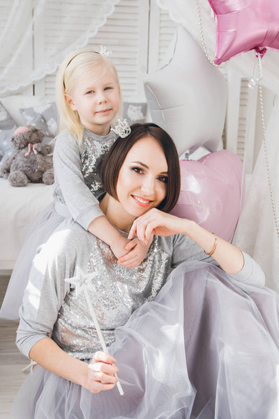 Happy mother and daughter in beautiful outfits celebrate the holiday with balloons. Toning. - Fotografie, Obrázek