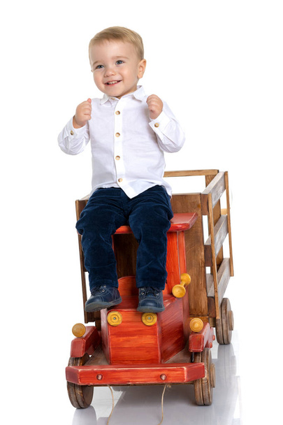 A little boy is playing with a toy car. - Zdjęcie, obraz