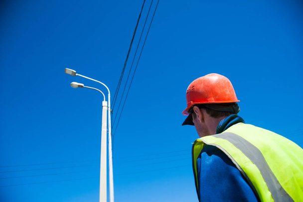 Elettricisti che riparano il filo della linea elettrica sul palo di energia elettrica - Foto, immagini