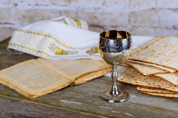 Fiestas judías Pesaj matzá Pascua y copa de plata llena de vino con una tradicional bendición Kidush taza de vino
 - Foto, imagen