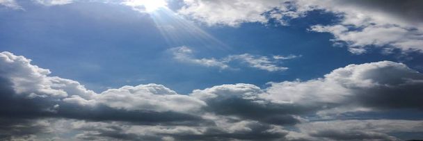 Lindas nuvens contra um fundo azul do céu. Céu nebuloso. Céu azul com tempo nublado, nuvem da natureza. Nuvens brancas, céu azul e sol
 - Foto, Imagem