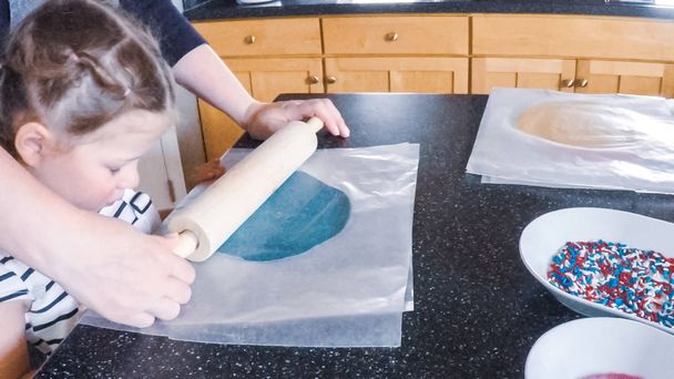 Askel kerrallaan. Äiti ja tytär leipoo sokeria evästeet keittiössä
. - Valokuva, kuva